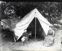 Woman and boy in front of tent