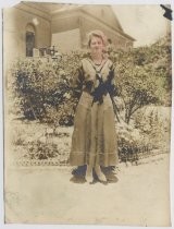 Young woman in school uniform in front of building