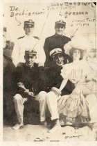 Group of four men in uniform posing with cardboard female figure