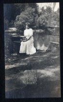 Woman posing next to mountain stream