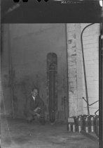 Unidentified man in suit kneeling next to aerial bomb