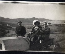 Two men and a woman with automobile in the desert