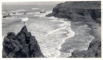 Man seated on rock above ocean