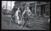 Two men with bicycles outside Maxwell Cyclery, Bisceglia Building