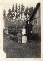 Rita, Frank and Tony Lewis next to a barn