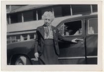 Unidentified older woman next to automobile