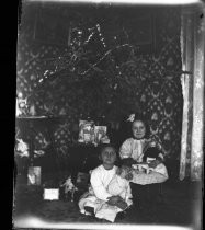 Two children posing with their dolls at Christmas