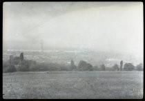 Looking into distance across wide field towards a city