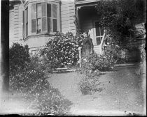 Woman in front of steps to house, c. 1912