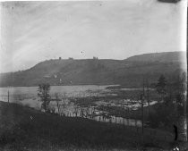 Farm on hillside seen from across a body of water, c. 1912