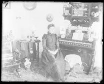 Woman seated at organ, inside home