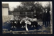 Men with flower-covered casket