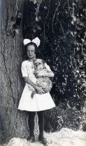 Young girl in white dress, holding a dog