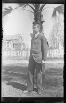 Young man in suit, in front of palm