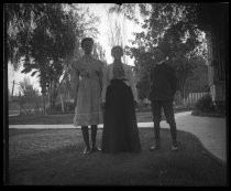 Woman with two children, standing on manicured lawn