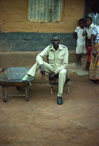 Mr. Stanley Kalumba, rural council postman and storyteller, in front of his home at Nsama village