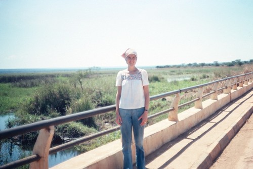 Donna Cancel poses on the bridge over the Choma River leading into central Kaputa village