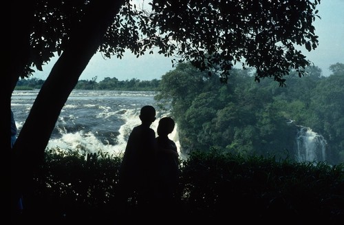 Two Boys watching Zambezi River flow over Victoria Falls, Livingstone