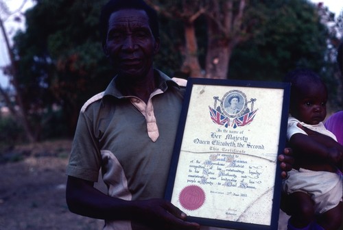 Paul Nsama with certificate recognizing his service as Acting-Chief