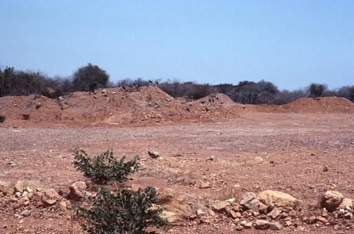 Dirt and gravel piled and ready to be used in new road construction near Nsama village