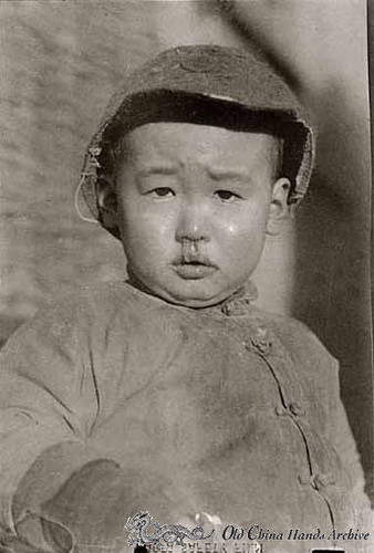 Child with a winter cold on a street in Tientsin street in 1946