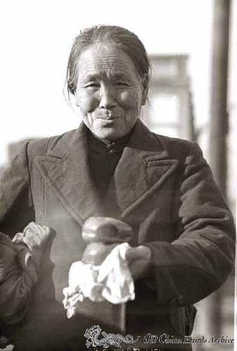 Elderly chinese woman buying steamed buns on street of Tientsin, 1946