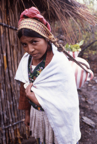 Guatemalan refugee carries ceramic pot on head, Chiapas, 1983