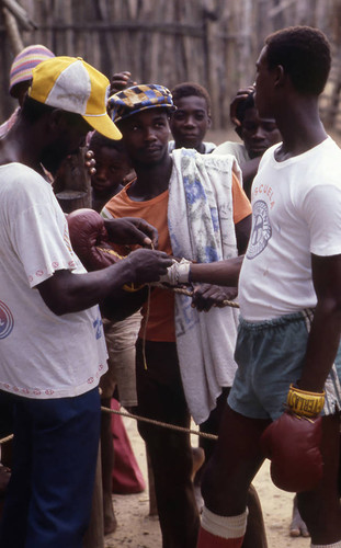 Man putting on boxing gloves, San Basilio de Palenque, 1976