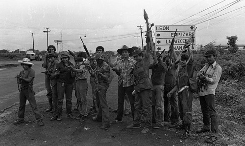 Sandinistas pose in front of a road sign, Nicaragua, 1979