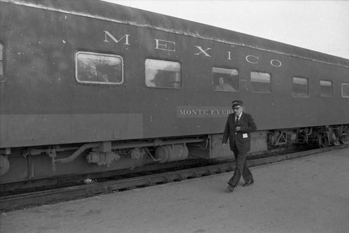 Train conductor walks along train, Mexico, 1983