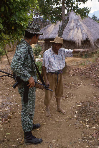 Soldier question Mayan man about guerilla movements, Guatemala, 1982