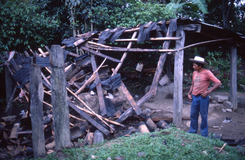 Man looks at destroyed shack, Honduras, 1983