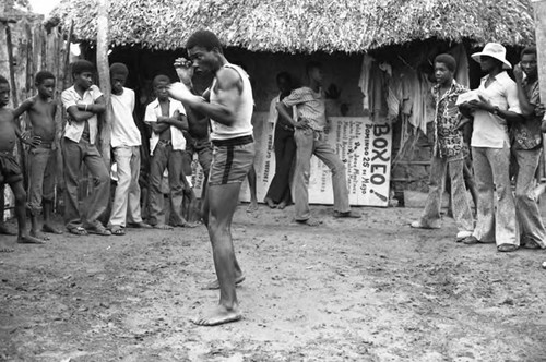 Man boxing outdoor in front of a crowd, San Basilio de Palenque, 1975