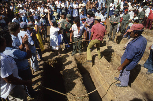 Three men lower the coffins, Nicaragua, 1983