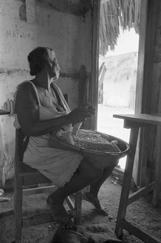 Woman removing corn from the cob, San Basilio de Palenque, 1976