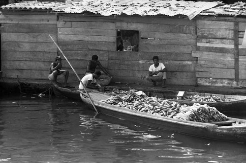 Four men next to two boats loaded with bananas, Cartagena Province, 1975