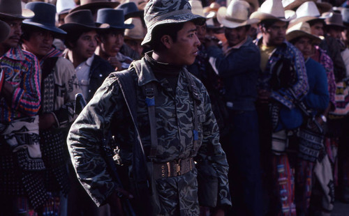 A soldier and a line of men, Nahualá, 1982