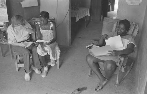 Nina S. de Friedemann and a woman looking at pictures, San Basilio del Palenque, ca. 1978