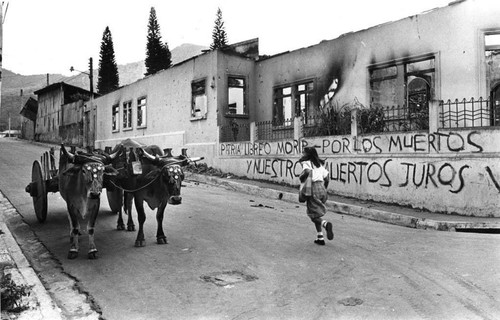 A girl runs in the street next to damaged buildings, Berlín, 1983