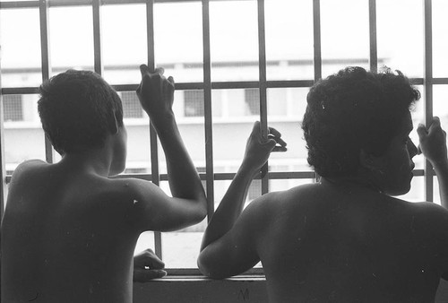 Prisoners look through bars, Nicaragua, 1980