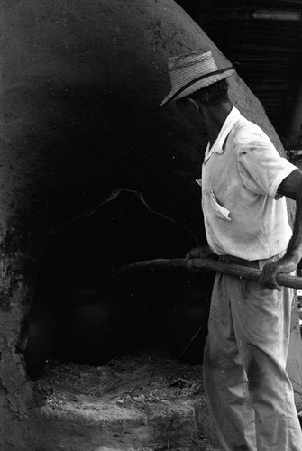 Man operating an oven, La Chamba, Colombia, 1975