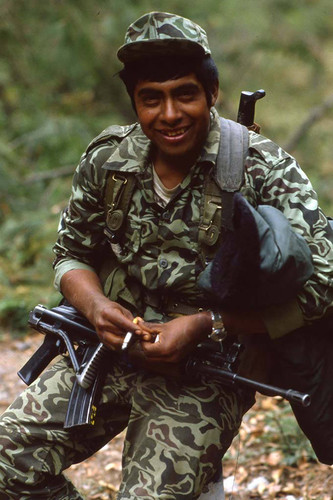 Armed soldier holding a cigarette, Chichicastenango, 1982