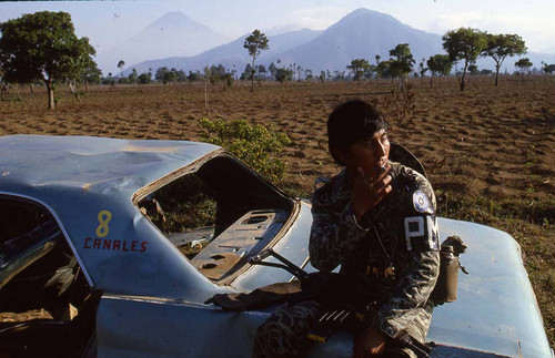 Armed soldier smoking a cigarette, Guatemala, 1982