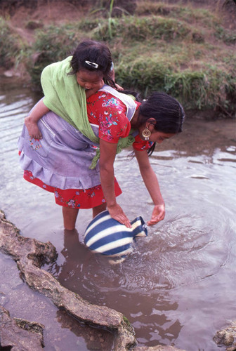 Guatemalan refugee collects water at a river, Cuauhtémoc, 1983