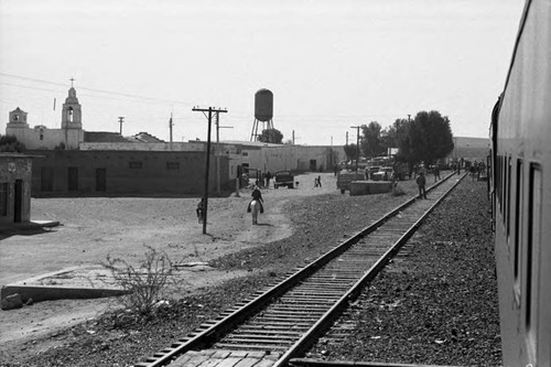 Train passes through a town, Chihuahua, Mexico, 1983