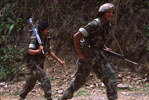 Contra soldiers walk along a road, Nicaragua, 1983