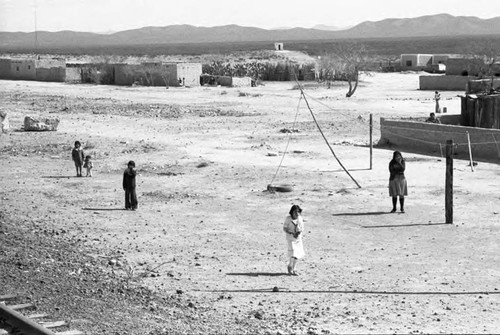 Woman and a group of children near train tracks, Chihuahua, 1983