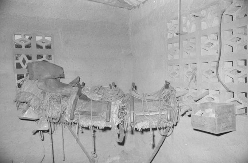 Saddles sitting on a beam inside a stable, San Basilio de Palenque, 1976