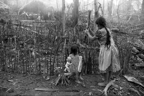 Refugee woman builds a fence of logs, Chiapas, 1983