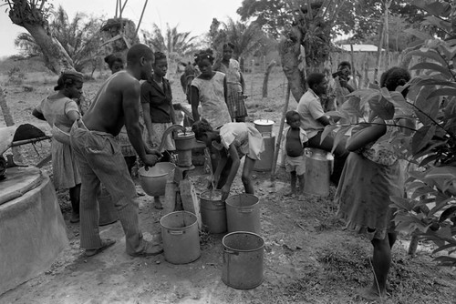 Man pumping water from a hand pump, San Basilio de Palenque, 1977